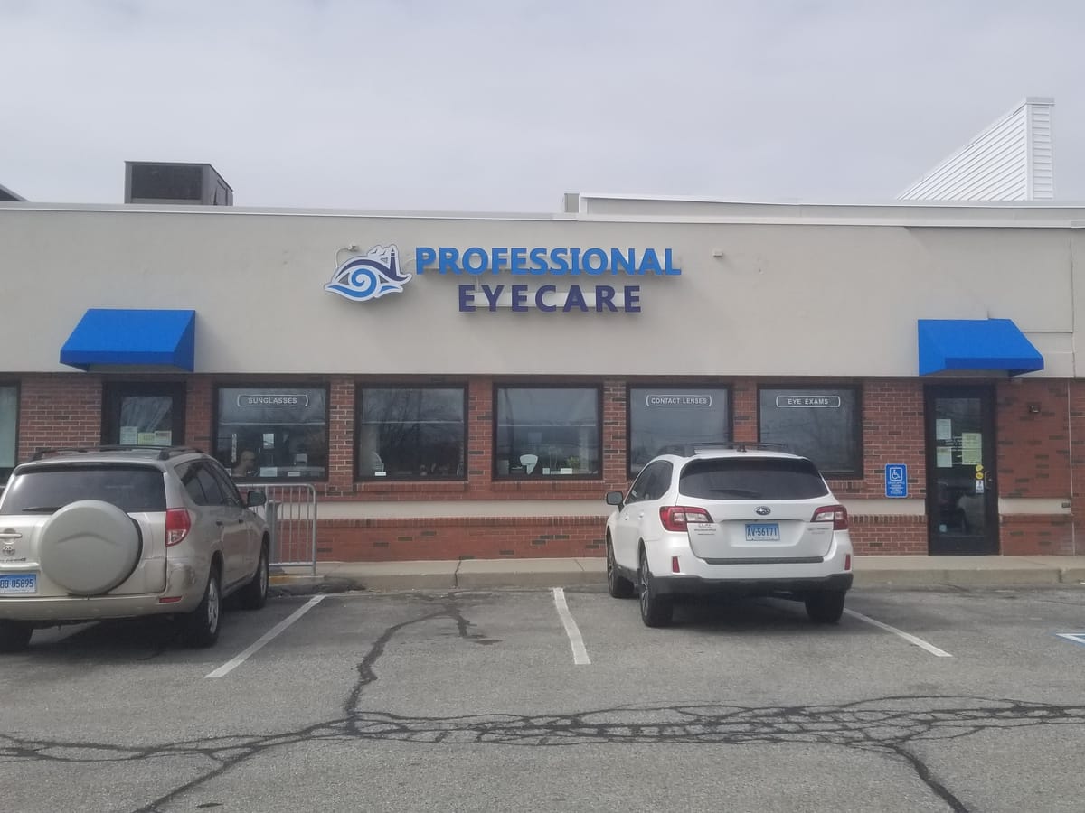 Blue shed-style door awnings over the entrance and windows of a brick storefront
