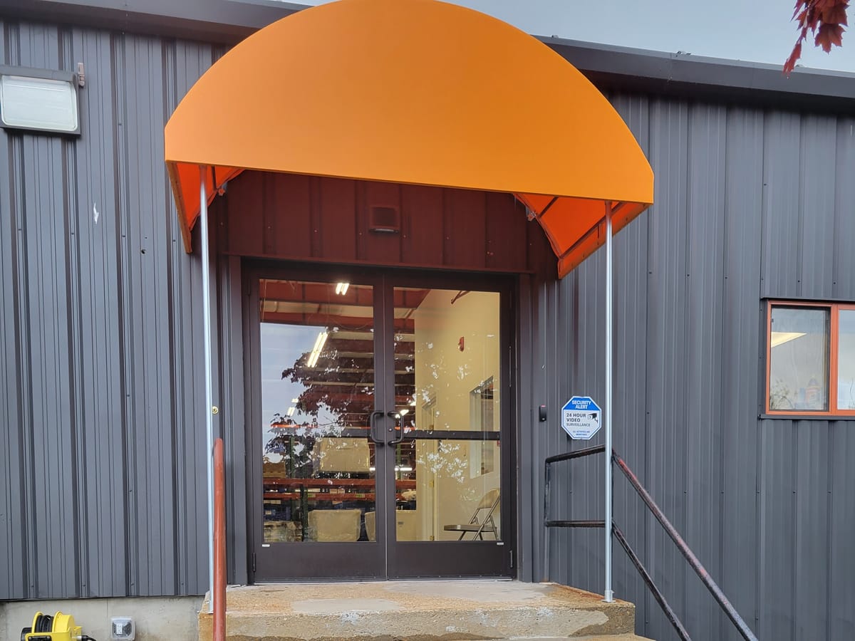 Orange dome canopy over the entry door of an industrial building