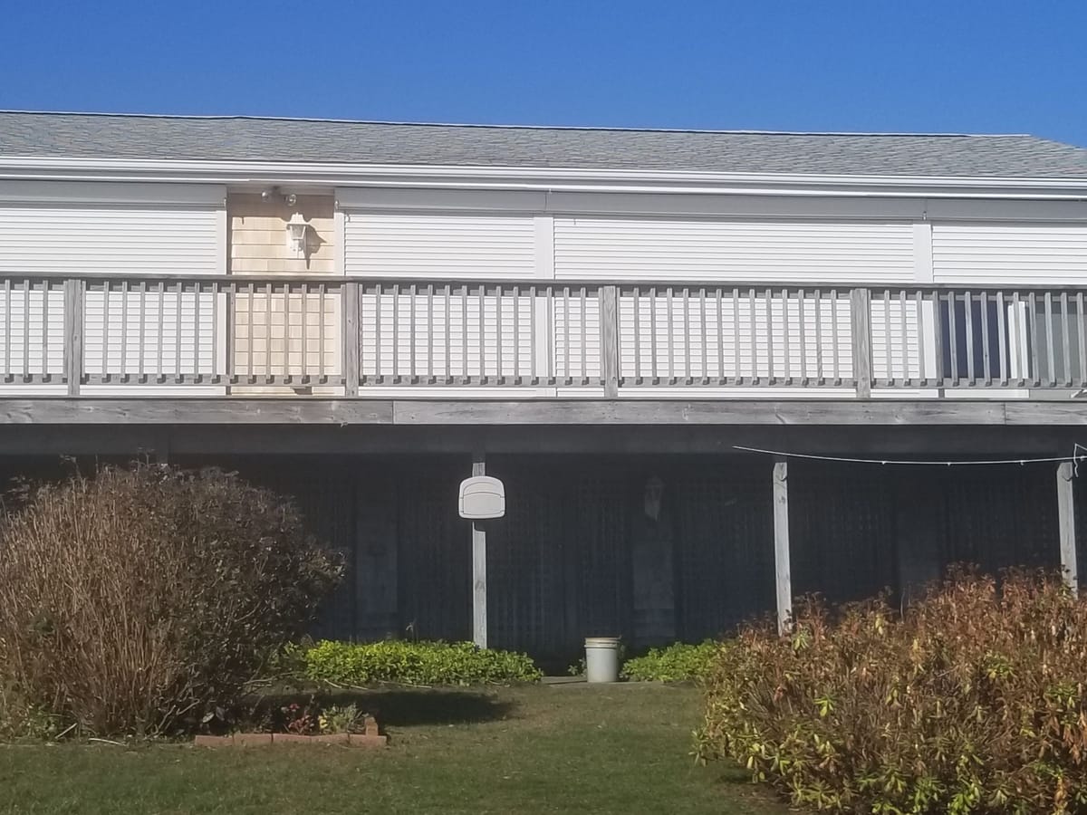 Roll-down hurricane shutters closed along the deck of a Matunuck oceanfront home