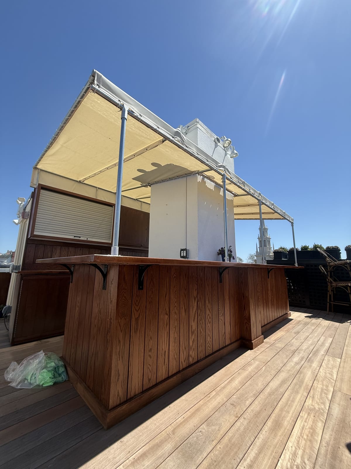 Canvas canopy over a rooftop bar with roll-up service shutters
