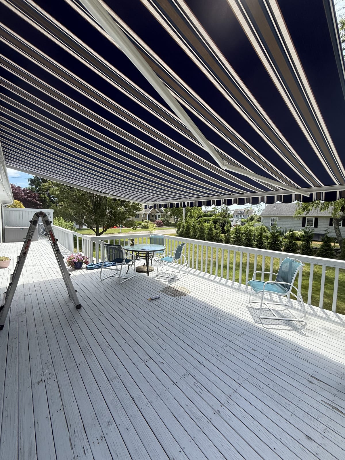 Navy striped retractable awning shading a backyard deck