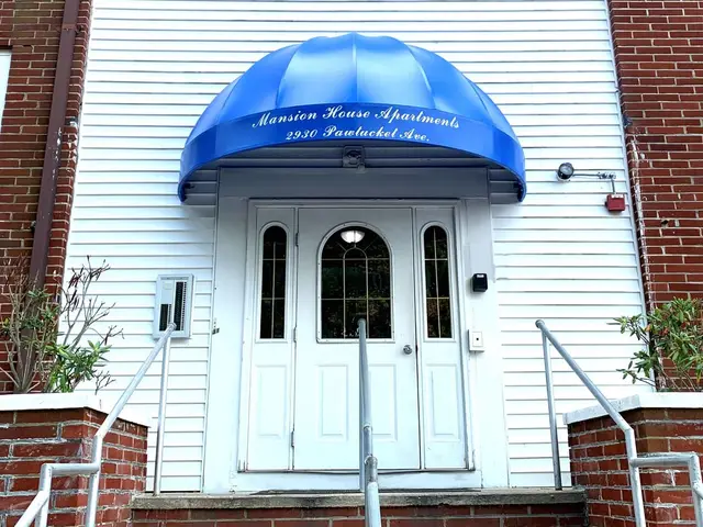 Blue dome entrance awning with script lettering over an apartment building doorway