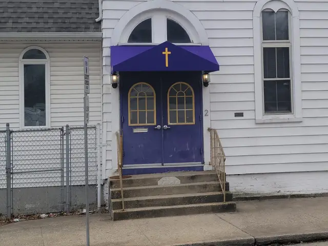 Purple door canopy with a gold cross over the front doors of a white church