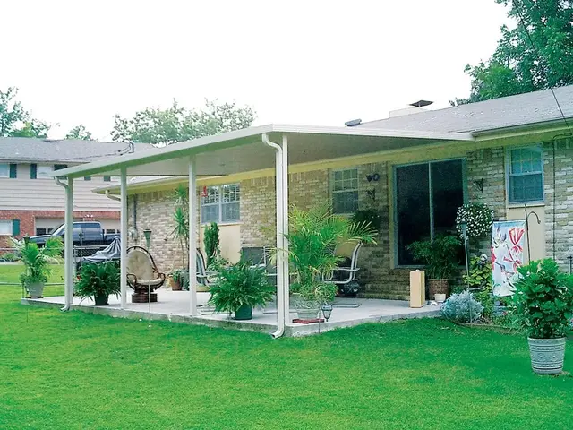 White aluminum hard-roof patio cover on a brick ranch