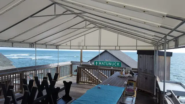White gabled canopy over an oceanfront dining deck in Matunuck, RI