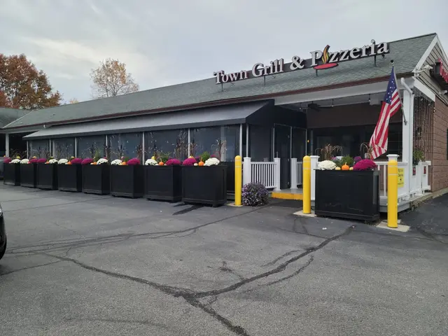 Black canopy with clear vinyl curtains enclosing the front patio at Town Grill & Pizzeria