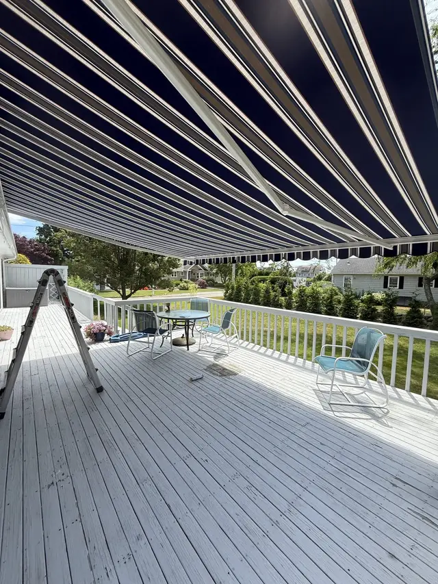 Navy striped retractable awning shading a backyard deck