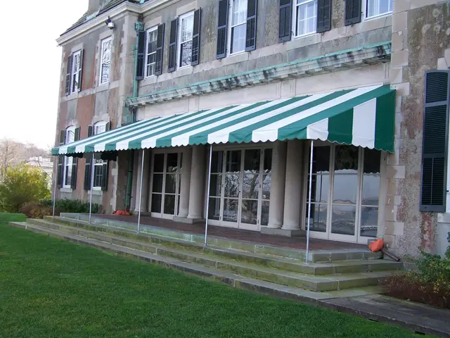Green striped porch awning across the stone terrace of a historic manor
