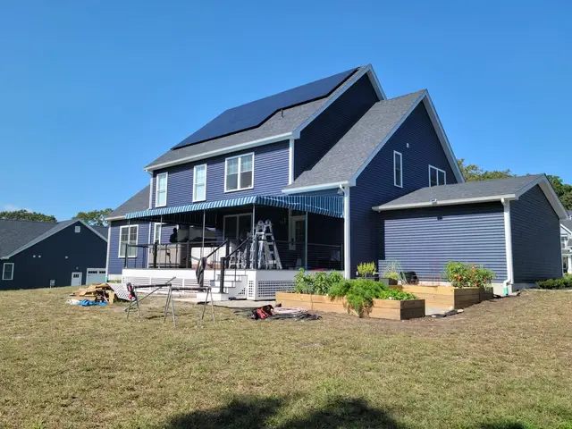 After — blue striped canopy over the same deck, crew finishing up
