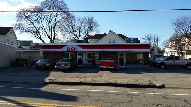 Red storefront awning with menu lettering across the front of a neighborhood deli