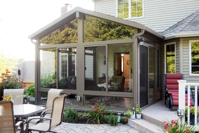 Bronze-frame gable sunroom on a backyard patio