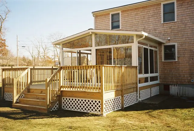Sunroom on a wide wood deck with lattice skirt