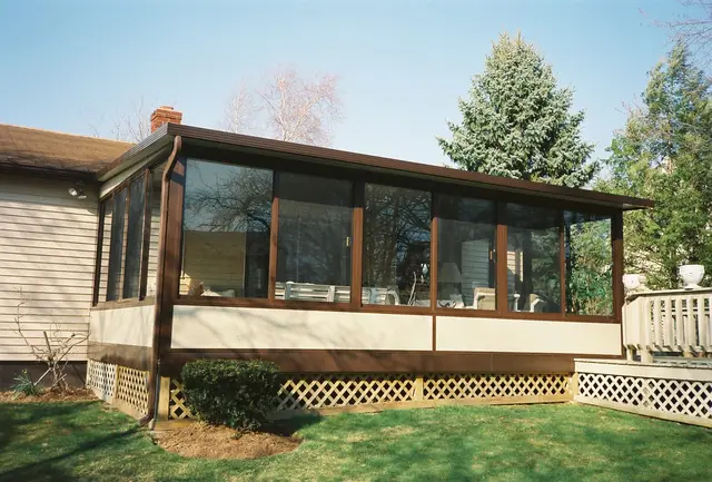 Bronze-frame sunroom across the back of the house